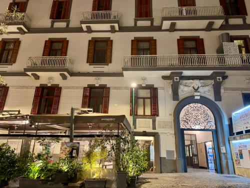 a large white building with a blue doorway at MILUAR Relais - Piazza Fuga in Naples