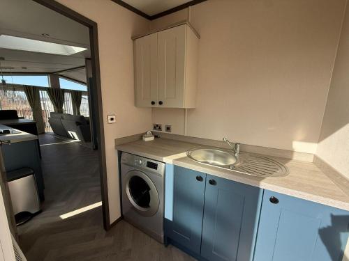a kitchen with a sink and a washing machine at Cedar Lodge - 27 Sunset View in Crowle
