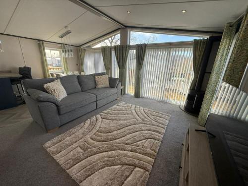 a living room with a couch and a rug at Cedar Lodge - 27 Sunset View in Crowle