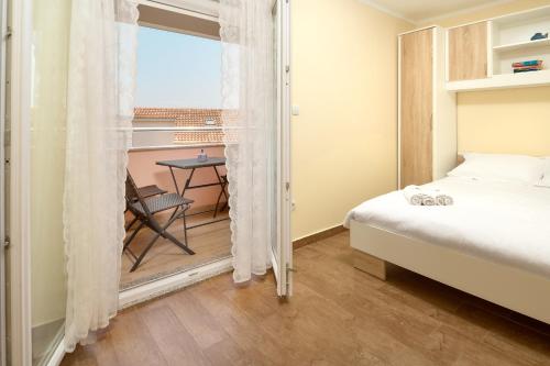 a bedroom with a bed and a table and a window at APARTMANI SABB in Jezera