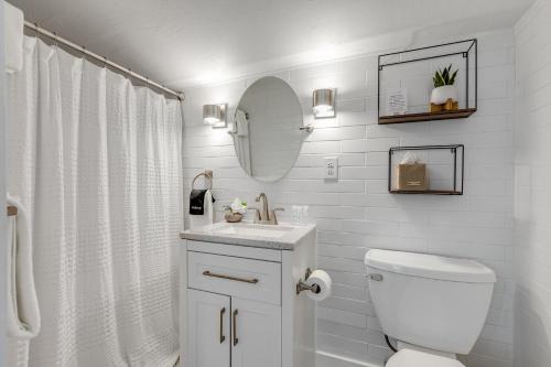a white bathroom with a toilet and a sink at HIDEAWAY @ Speakeasy Inn Key West! in Key West