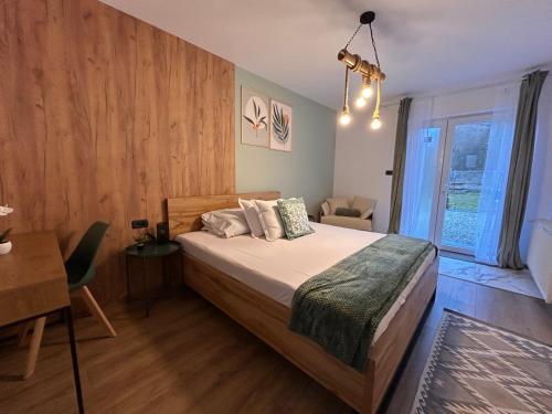 a bedroom with a bed with a wooden wall at Casa Irinei in Poiana Mărului