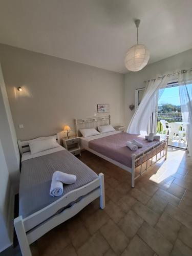 a bedroom with two beds and a large window at Musses Studios in Minia