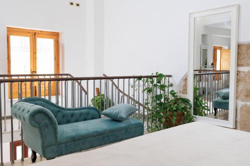 a blue chair sitting on a balcony with a mirror at Ire' Luxury Suite in Avola