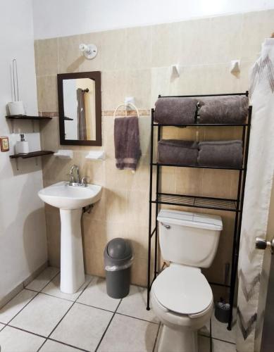 a bathroom with a toilet and a sink at Bonsai House in Ramos Arizpe
