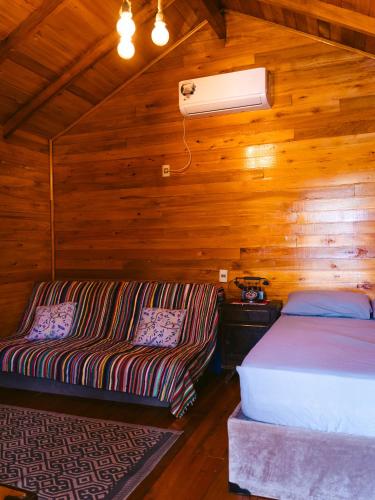 a bedroom with a bed and a couch in a cabin at Chalet del lago Don Asterio in Ciudad del Este