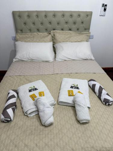 a bed with white towels and pillows on it at Refugio del Alma in Villa Anizacate