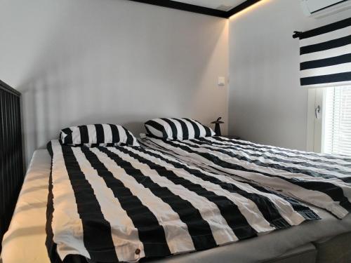 a black and white bed in a bedroom with two pillows at Pihapiilo in Raahe