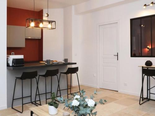 a kitchen with a counter and stools in a room at Notre Dame de Senlis by La boite en Plus in Senlis