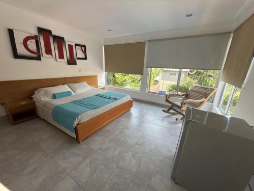 a bedroom with a bed and a chair in it at Hotel Montanar HOME in La Dorada