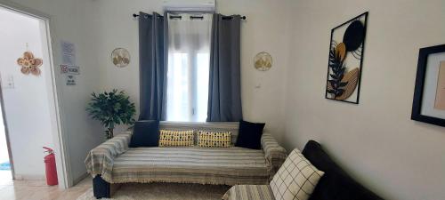 a living room with a couch in front of a window at Diamond apartments in Artemida