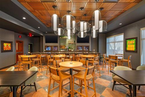 a restaurant with tables and chairs and a bar at Drury Plaza Hotel St Louis Brentwood in Brentwood