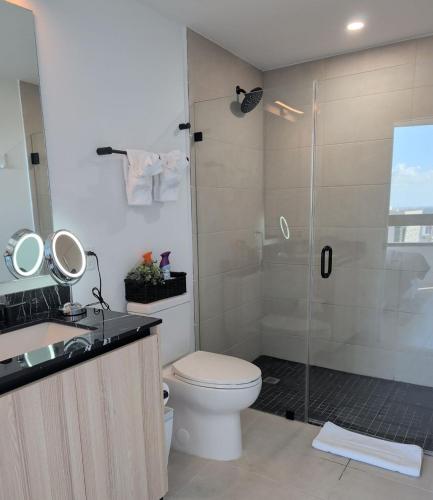 a bathroom with a shower with a toilet and a sink at District 225 in Miami