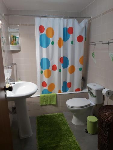 a bathroom with a toilet and a shower curtain at Madeira Home Holidays in Caniço