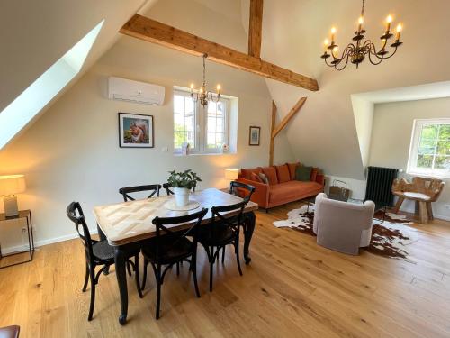 a living room with a table and chairs and a couch at Le Hêtre Rouge - Écureuil et Geai Charme & Spa Alsace in Barr