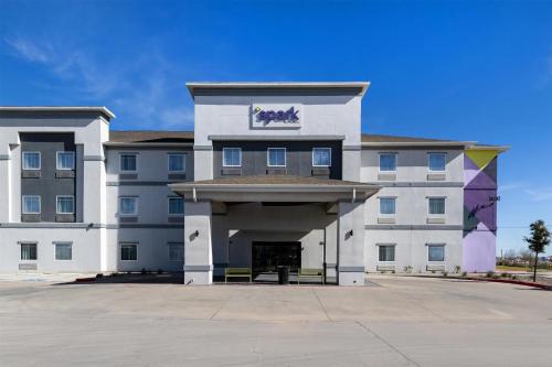 a large white building with a sign on it at Spark by Hilton Midland South in Midland
