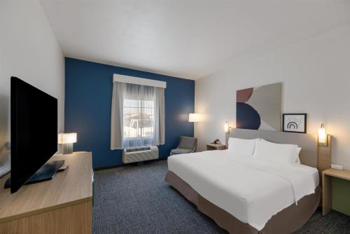 a hotel room with a bed and a tv at Spark by Hilton Midland South in Midland
