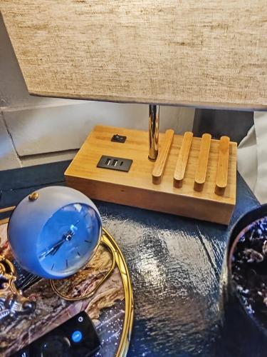 a clock sitting on top of a wooden board at Cosy Studio in Hampton Hill short Walk to Bushy Park with Free Parking and WiFi and Pets welcome in Hampton Hill