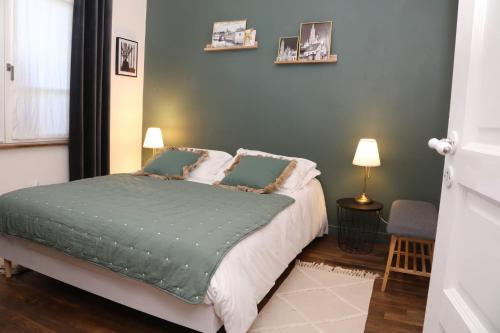a bedroom with a bed with green sheets and pillows at Suite Garden by La Boîte En Plus in Senlis
