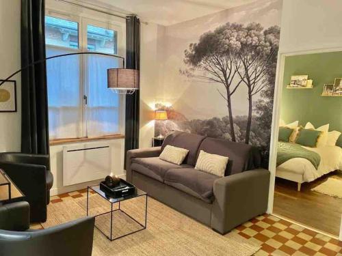 a living room with a couch and a bedroom at Suite Garden by La Boîte En Plus in Senlis