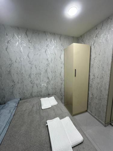 a room with a bed and a cabinet in it at White Apartment in Baku