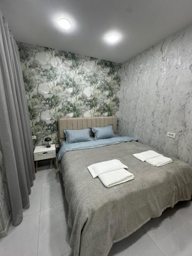 a bedroom with a bed with towels on it at White Apartment in Baku