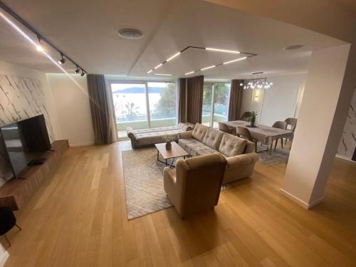 a living room with a couch and a table at Beachfront 2BR Apartment with Balcony and Sea View, Biser Mora in Rafailovici