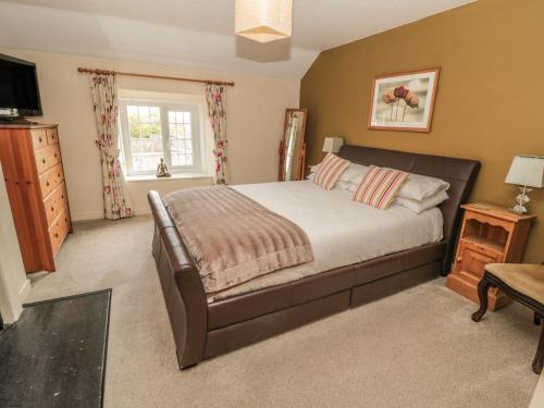 a bedroom with a large bed and a television at Shepherds Nook in Chathill