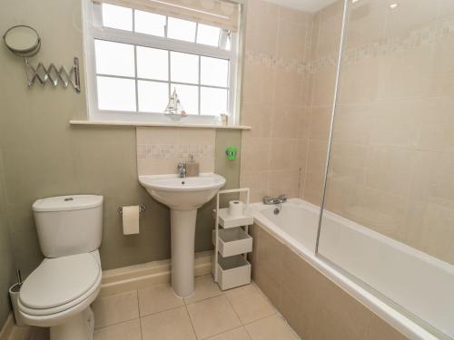 a bathroom with a toilet and a sink and a tub at Shepherds Nook in Chathill