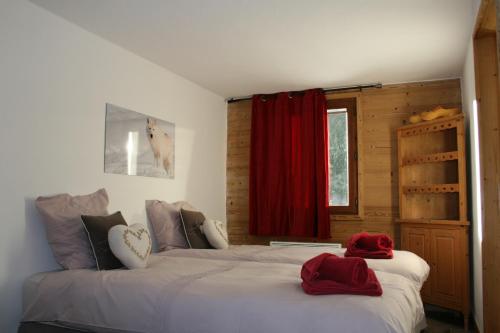 a bedroom with two beds with red towels on them at La Chanterelle - Mountain Lodge in La Côte dʼArbroz