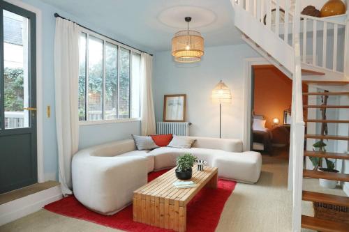 a living room with a couch and a table at La Maison des Rues Pavées avec jardin by La Boîte En Plus in Senlis