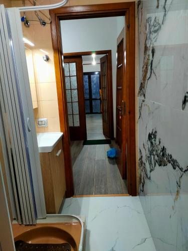 a bathroom with a toilet and a sink and a hallway at casa vacanze Libeccio parcheggio privato in Sapri