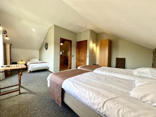 a hotel room with two beds and a desk at Le Grand Vallon in Polleur