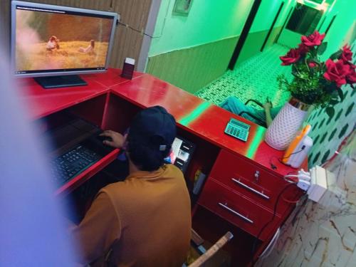 a person sitting in front of a desk with a computer at Palace inn Hotel in Dargai