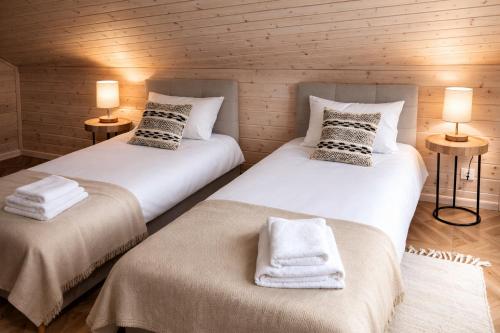 two twin beds in a room with two lamps at Przylesie Domki in Wysoczany