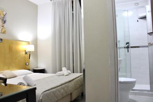 a hotel room with a bed and a bathroom at Hotel Fiorella Milano in Milan