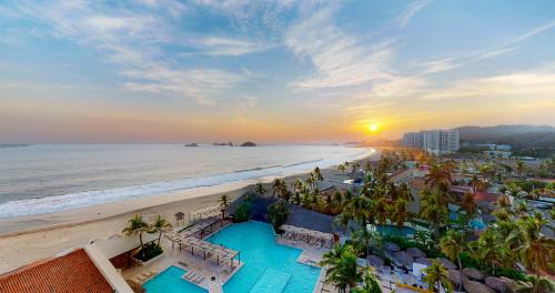 a view of the beach and the ocean at sunset at Park Royal Beach Ixtapa - All Inclusive in Ixtapa