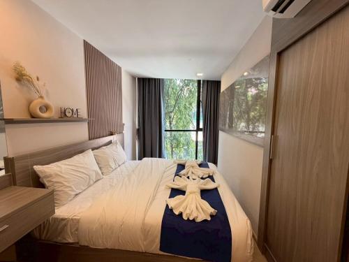 a bedroom with a bed with a robe on it at The Iconic in Pattaya