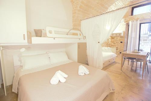 a bedroom with a bed with two white towels on it at Rubini's House in Giovinazzo