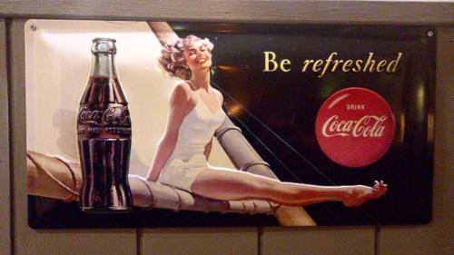 a coca cola sign on the wall of a bathroom at Møn Klintholm Vintage B&B in Borre