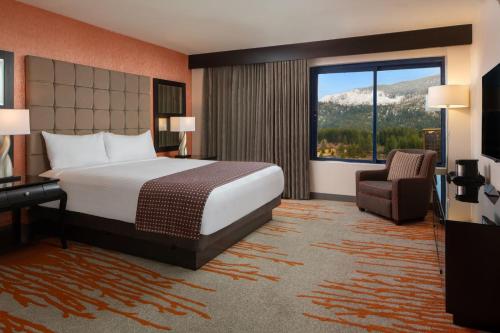 a hotel room with a bed and a chair and a window at Golden Nugget Lake Tahoe in Stateline