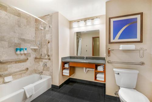 a bathroom with a tub and a toilet and a sink at Drury Plaza Hotel St Louis Brentwood in Brentwood