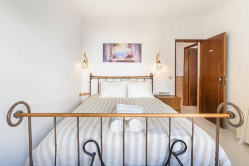 a bedroom with a bed with a metal frame at Casa da Bé in Vila Nova de Milfontes