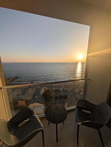a balcony with two chairs and a view of the ocean at LISI apartments in Lezhë