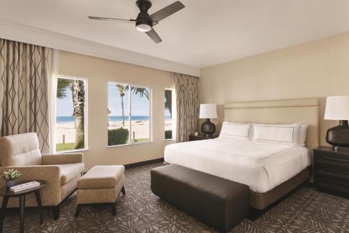 a hotel room with a bed and a chair at Zachari Dunes on Mandalay Beach, Curio Collection by Hilton in Oxnard