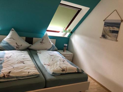a bedroom with a bed and a window and a window at Ferienhaus Victoria in Norden