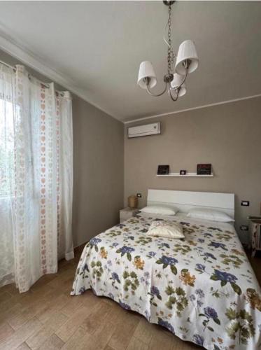 a bedroom with a bed and a chandelier at Nonna Maria B&B Home restaurant in La Marinella