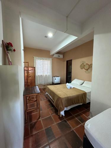 a bedroom with a bed and a table in a room at Pousada Casa do Josef in Canoa Quebrada