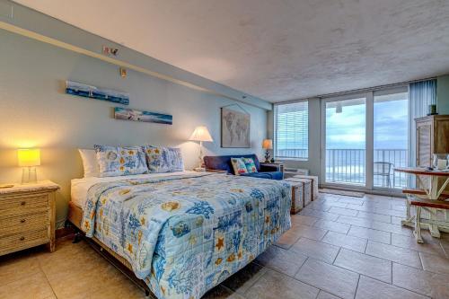 a bedroom with a bed and a large window at The Ocean Calls Harbour Beach 612 in Daytona Beach