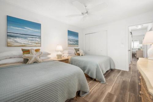 a bedroom with two beds and a ceiling fan at 2 Bedroom Bayside Condo with Pool in OCMD in Ocean City